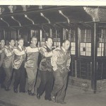 8 Personen bilden eine Polonaise vor dem Postwagen 1954