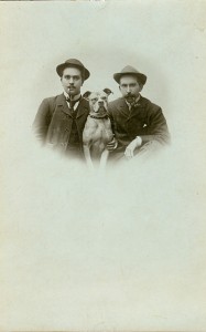 Zwei Männer mit Peiffe und einem Hund