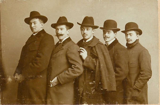 Fünf Studenten im Anzug und Hut stehen hintereinander