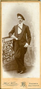 Junger Mann, mit Mütze und Schärpe und Handschuhen vor Geländer