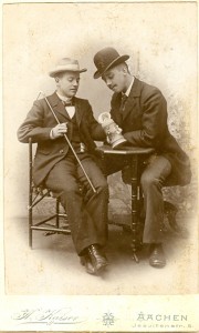 Zwei Studenten mit Hüten, sitzend an einem Tisch mit Bierkrug